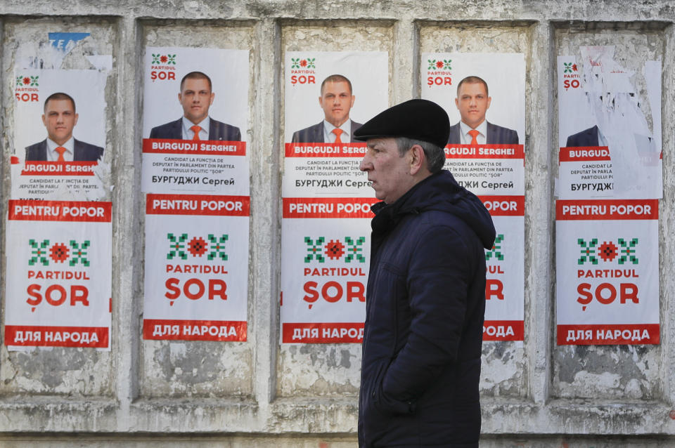 A man walks by electoral posters advertising the candidates of the the Show party, led by Israeli born Modovan businessman Ilan Shor, in Chisinau, Moldova, Thursday, Feb. 21, 2019, ahead of parliamentary elections taking place on Feb. 24. Moldova's president says the former Soviet republic needs good relations with Russia, amid uncertainty about the future of the European Union. (AP Photo/Vadim Ghirda)