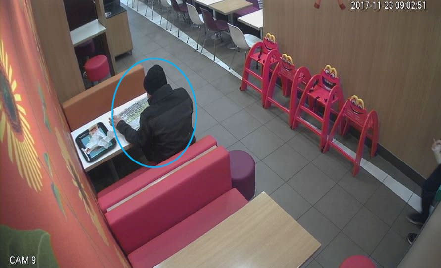 He was seen on CCTV enjoying a McDonald's meal while reading the paper (SWNS)