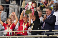 Manchester United manager Marc Skinner, center right, and player Millie Turner lift the trophy after winning the Women's FA Cup final soccer match between Manchester United and Tottenham Hotspur at Wembley Stadium in London, Sunday, May 12, 2024. Manchester United won 4-0. (AP Photo/Kirsty Wigglesworth)