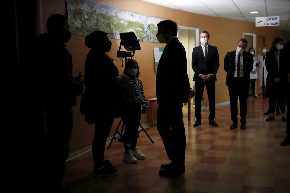 French President Emmanuel Macron, center silhouetted, visits a child psychiatry department at Reims hospital, eastern France, to discuss the psychological impact of the COVID-19 crisis and the lockdown on children and teenagers in France, Wednesday, April 14, 2021. (Christian Hartmann/Pool via AP)