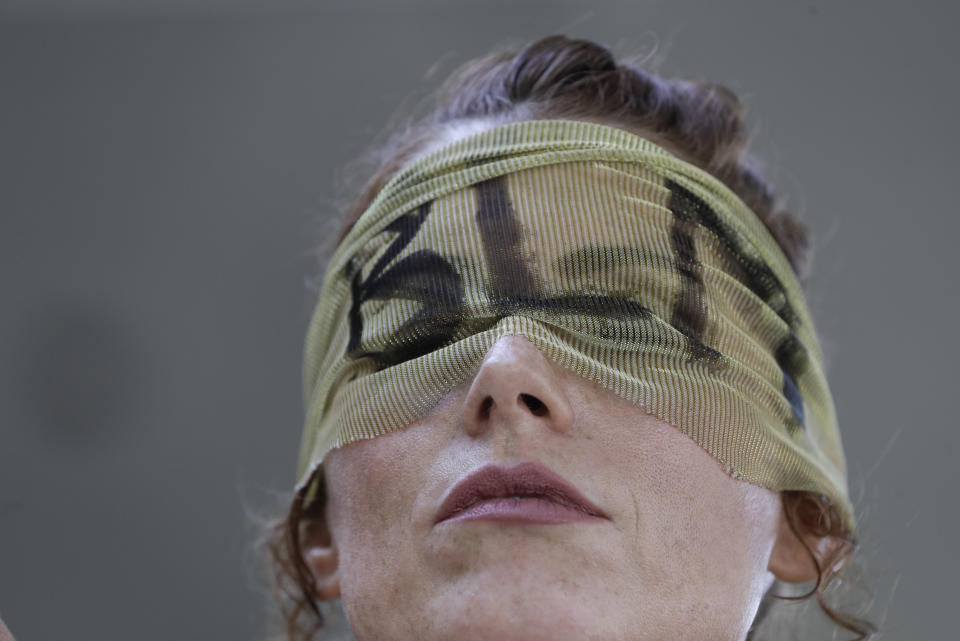 Sarah McKinnie, a veil fabric with the initials BLM for Black Lives Matter covering her eyes, during a protest over the deaths of George Floyd and Breonna Taylor, in Louisville, Ky., Tuesday, June 2, 2020. Taylor was fatally shot by Louisville Metro police in her home in March. Floyd died after being restrained by Minneapolis police officers on Memorial Day. (AP Photo/Darron Cummings)