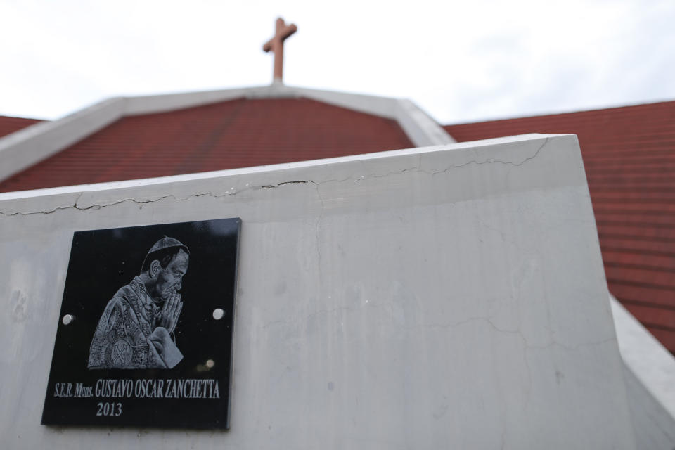 A plaque with the image of Bishop Gustavo Zanchetta is seen outside the cathedral in Oran, Argentina, on Wednesday, Jan. 16, 2019. Earlier in January, the Vatican confirmed that the new bishop of Oran had opened a canonical investigation into Zanchetta for alleged sexual abuses. (AP Photo/Natacha Pisarenko)