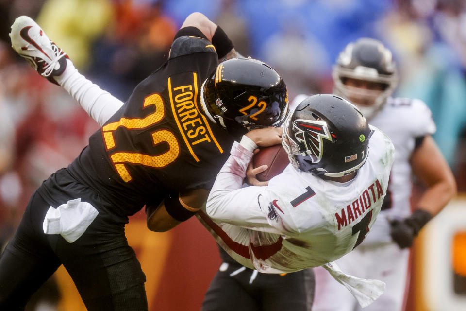 Washington Commanders safety Darrick Forrest (22) stops an airborne Atlanta Falcons quarterback Marcus Mariota (1) during the first half of a NFL football game between the Atlanta Falcons and the Washington Commanders on Sunday, Nov. 27, 2022 at FedExField in Landover, Md. (Shaban Athuman/Richmond Times-Dispatch via AP)