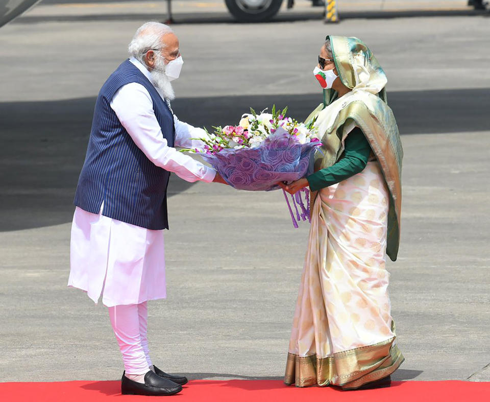 In this photo provided by Prime Minister of India Narendra Modi's twitter handle, Indian Prime Minister Narendra Modi receives a bouquet of flowers from Bangladesh's Prime Minister Sheikh Hasina in Dhaka, Bangladesh, Friday, March 26, 2021. Modi arrived in Bangladesh’s capital on Friday to join celebrations marking 50 years of the country's independence, but his trip was not welcomed by all. The two-day visit, his first foreign trip since the coronavirus pandemic began last year, will also include joining commemorations for 100 years since the birth of independence leader Sheikh Mujibur Rahman, the father of current Prime Minister Sheikh Hasina. (Prime Minister of India Narendra Modi's twitter handle via AP Photo)