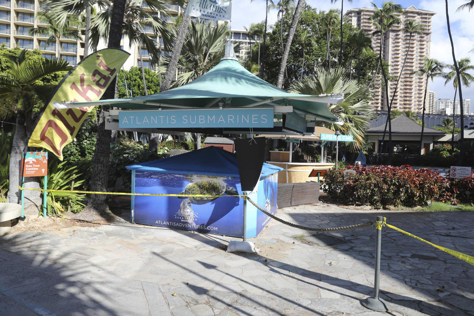 An entrance to a popular resort in Waikiki is closed off to the public Thursday, Oct. 15, 2020, in Honolulu. A new pre-travel testing program will allow visitors who test negative for COVID-19 to come to Hawaii and avoid two weeks of mandatory quarantine goes into effect Thursday. The pandemic has caused a devastating downturn on Hawaii's tourism-based economy and many are hoping the testing will help the economy rebound. (AP Photo/Marco Garcia)