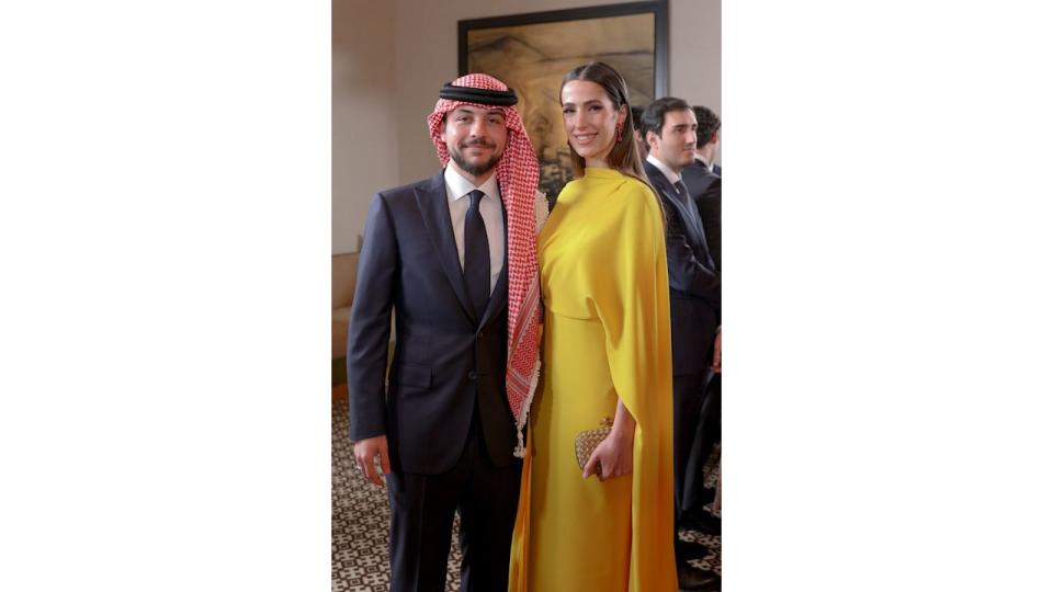 Crown Prince Hussein standing with Princess Rajwa, who wears a yellow dress