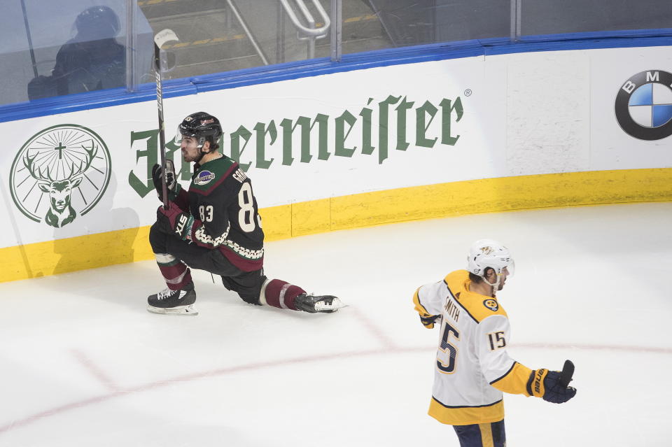 Nashville Predators' Craig Smith (15) skates past as Arizona Coyotes' Conor Garland (83) celebrates a goal during the third period of an NHL hockey playoff game Wednesday, Aug. 5, 2020 in Edmonton, Alberta. (Jason Franson/The Canadian Press via AP)