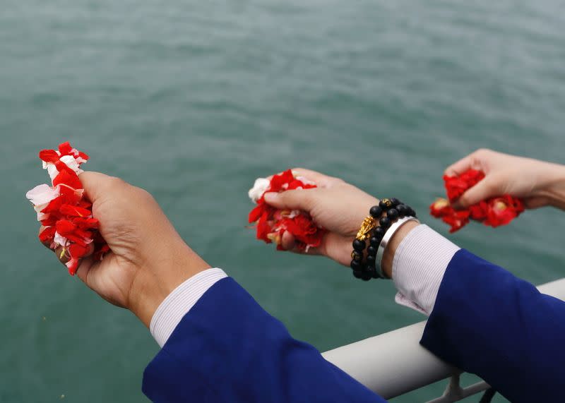 Colleagues of the crew members of Sriwijaya Air flight SJ 182, which crashed into the sea, throw flowers and petals from the deck of Indonesia's Naval ship KRI Semarang as they visit the site of the crash to pay their tribute, at the sea off the Jakarta