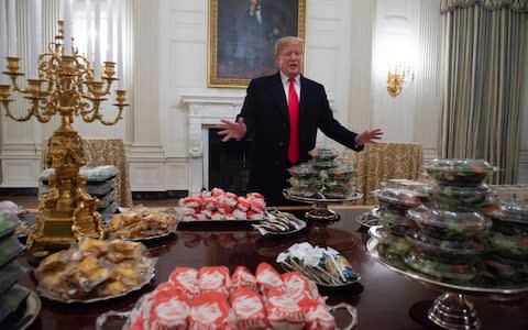 US President Donald Trump speaks alongside fast food he purchased for a ceremony honoring the 2018 College Football Playoff National Champion Clemson Tigers in the State Dining Room of the White House in Washington, DC, January 14, 2019 - Credit: SAUL LOEB/AFP