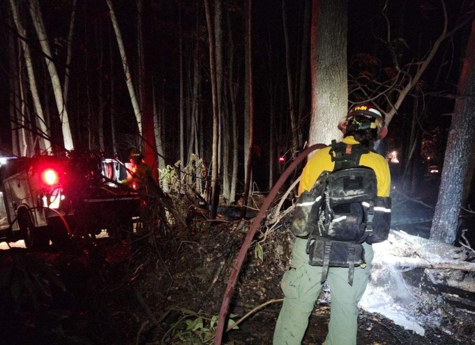 A firefighter works on containing the Poplar Drive Fire on the night of Nov. 12 on Bald Top Mountain in Edneyville.