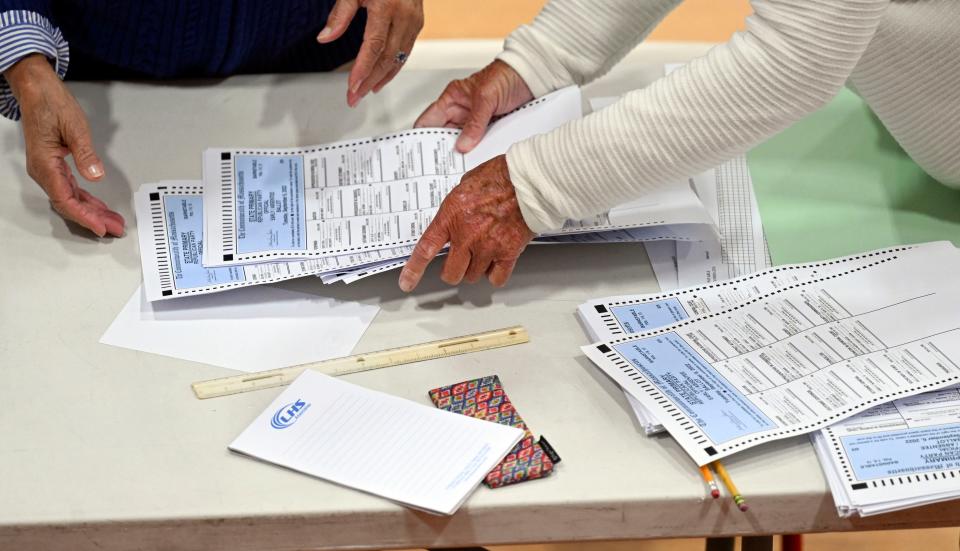 Election workers count ballots for Barnstable precincts 8, 9 and 13 at the Hyannis Youth and Community Center after midnight Wednesday. A malfunction with a Town Hall vault led to a four-hour delay in voting on Tuesday.