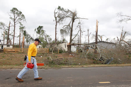 A volunteer walks past the Big Pine Estates Mobile Home Park after a tornado struck the residential area on Sunday, in Albany, Georgia. REUTERS/Tami Chappell