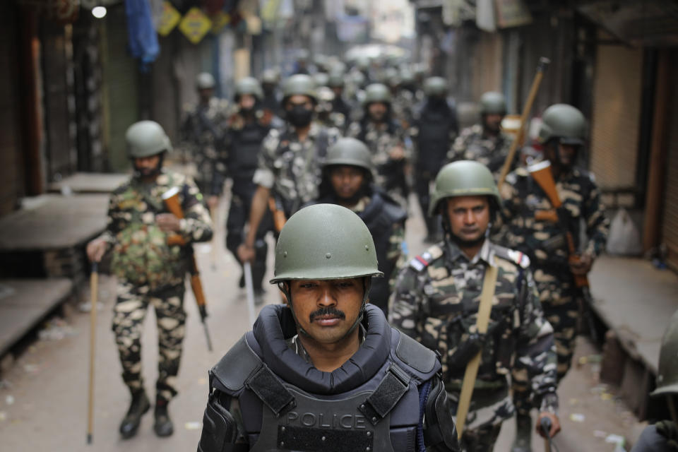 Indian security officers patrol a street in New Delhi, India, Wednesday, Feb. 26, 2020. At least 20 people were killed in three days of clashes in New Delhi, with the death toll expected to rise as hospitals were overflowed with dozens of injured people, authorities said Wednesday. The clashes between Hindu mobs and Muslims protesting a contentious new citizenship law that fast-tracks naturalization for foreign-born religious minorities of all major faiths in South Asia except Islam escalated Tuesday. (AP Photo/Altaf Qadri)