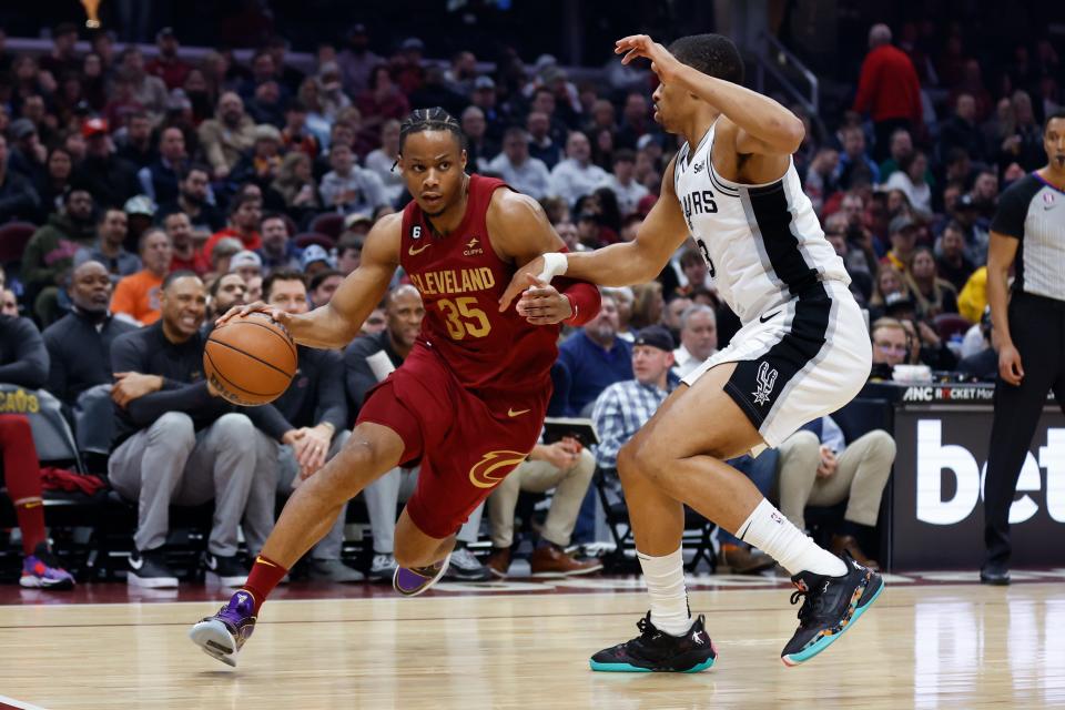 Cleveland Cavaliers forward Isaac Okoro (35) drives against San Antonio Spurs forward Keldon Johnson during the first half of an NBA basketball game, Monday, Feb. 13, 2023, in Cleveland. (AP Photo/Ron Schwane)