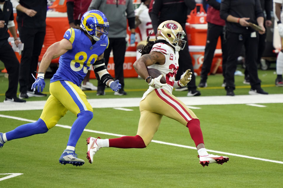 San Francisco 49ers cornerback Richard Sherman, right, runs back with an intercepted pass next to Los Angeles Rams tight end Tyler Higbee (89) during the first half of an NFL football game Sunday, Nov. 29, 2020, in Inglewood, Calif. (AP Photo/Alex Gallardo)