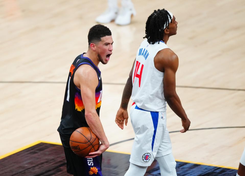 Phoenix Suns guard Devin Booker celebrates next to Los Angeles Clippers guard Terance Mann in the closing seconds of Game 1.