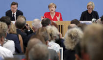 German Chancellor Angela Merkel, rear center, addresses the media during her annual sommer press conference in Berlin, Germany, Friday, July 19, 2019. (AP Photo/Michael Sohn)