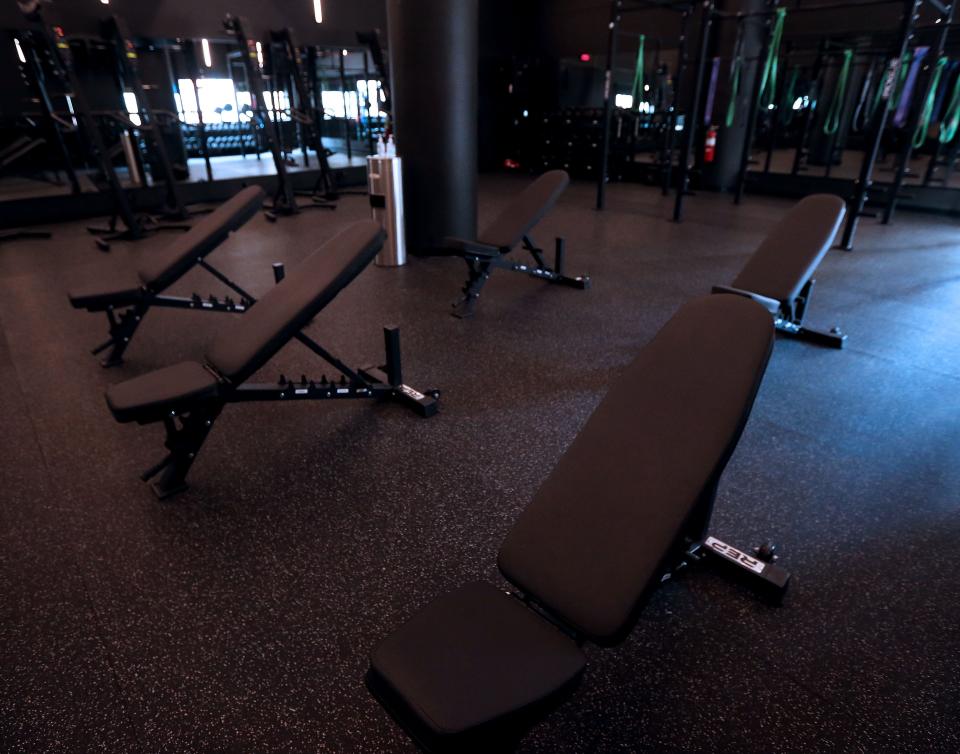 Workout benches are seen at Train Moment, a new fitness facility that is owned by Kati Rodriguez and Nik on Tuesday, Nov. 16, 2021. Train Moment, a "strength-forward" fitness facility in the Third Ward at 323 North Milwaukee St. This is the second location for their business that originated in Chicago's West Loop. The business offers full-body group workouts. While the lobby is white and simple with greenery, the training room has a drastically different vibe. It's all black with dim lights and blackout blinds.