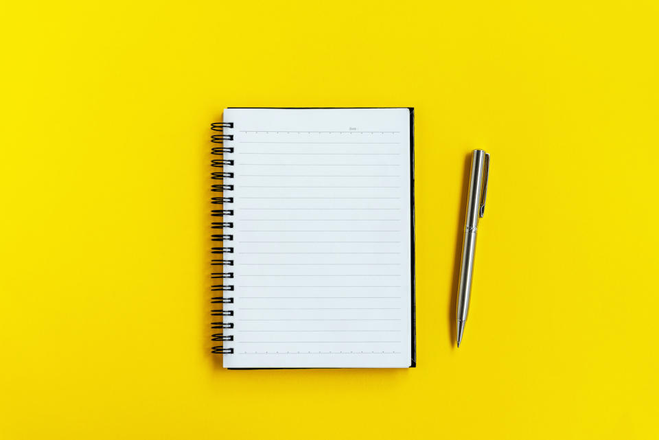 Note Pad and Pen on Yellow background