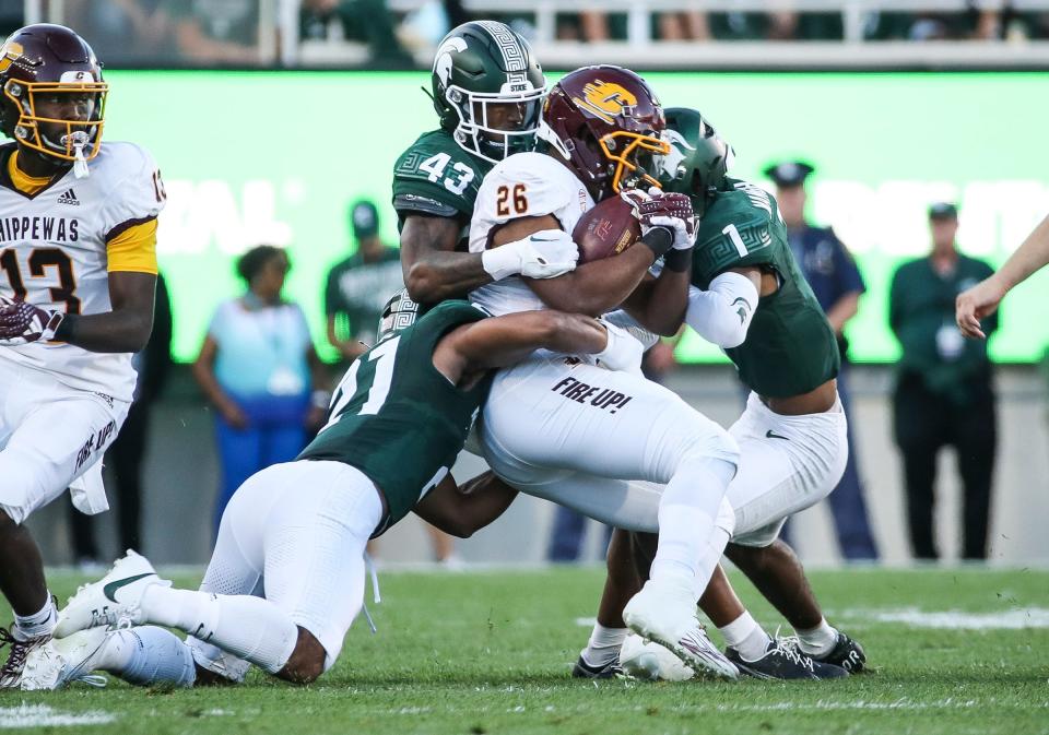 Michigan State defensive backs Malik Spencer (43), defensive back Jaden Mangham (1) and Dillon Tatum (bottom) stop Central Michigan running back Myles Bailey (26) during the first half at Spartan Stadium in East Lansing on Friday, Sept. 1, 2023.