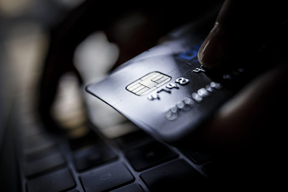 BERLIN, GERMANY - FEBRUARY 02: Symbolic photo on the subject of online shopping. A credit card is held next to the keyboard of a laptop. (Photo by Thomas Trutschel/Photothek via Getty Images)