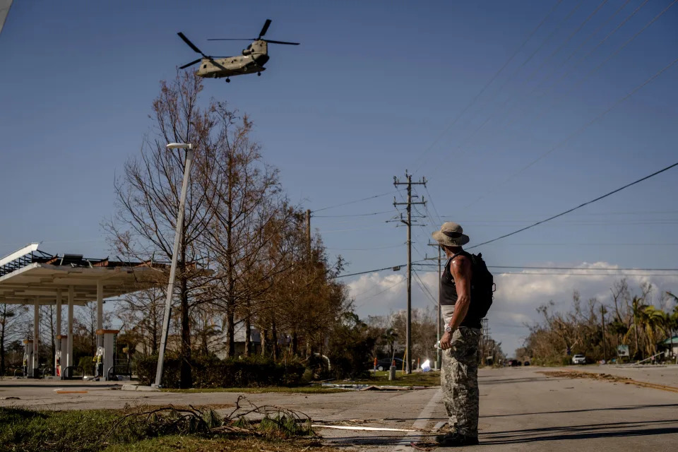 A helicopter carries evacuees from Pine Island, Fla., on Saturday, Oct. 1, 2022. (Hilary Swift/The New York Times)