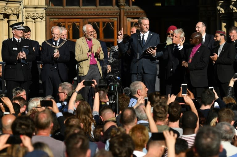 Hushed laughter broke the silence of the crowd, which was followed by huge applause at the end of poet Tony Walsh's (C) address after the bombing of the Manchester Arena