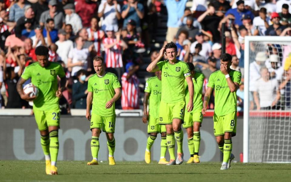 Manchester United players trudge back to the centre circle, looking miserable, after conceding to Brentford