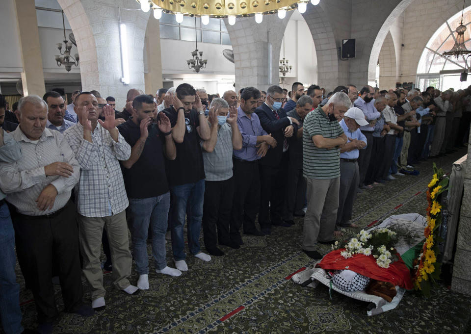 Palestinian mourners pray near the body of Suha Jarrar, 30-year-old, daughter of Khalida Jarrar who is a prisoner in an Israeli jail, during her funeral, in the West Bank city of Ramallah, Tuesday, July 13, 2021. Khalida Jarrar, 58, a leading member of the Popular Front for the Liberation of Palestine, has been in and out of Israeli prison in recent years. Palestinian activists and human rights groups urged Israel to allow Jarrar to attend her daughter’s funeral. (AP Photo/Majdi Mohammed)