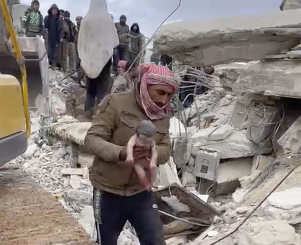 A rescuer carries a baby girl after pulling her from the rubble caused by an earthquake that hit Syria and Turkey in the town of Jinderis, Syria, Tuesday, Feb. 7, 2023. Residents in the northwest Syrian town discovered the crying infant whose mother gave birth to her while buried underneath the rubble of a five-story apartment building levelled by this week's devastating earthquake, relatives and a doctor say. (Via AP)