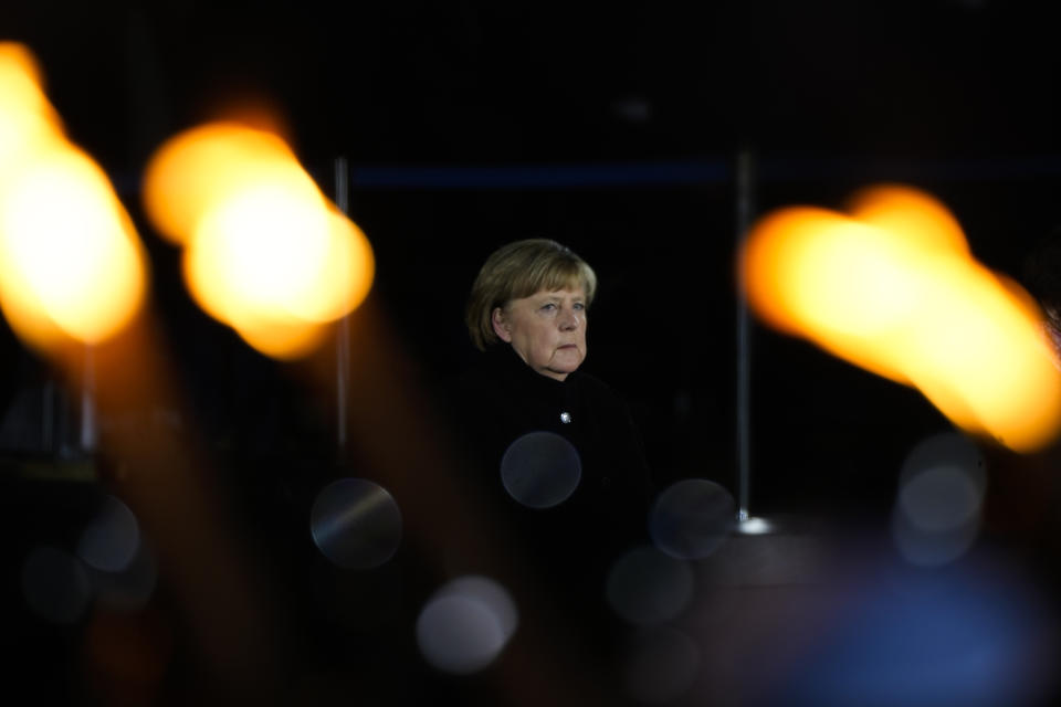 Chancellor Angela Merkel attends in a Grand Tattoo ceremony to mark the farewell of her chancellorship in Berlin, Germany, Thursday, Dec. 2, 2021. With one week left before Merkel steps aside, she is being treated to a traditional send off involving the military ceremony with a brass band playing her choice of music. (AP Photo/Markus Schreiber)