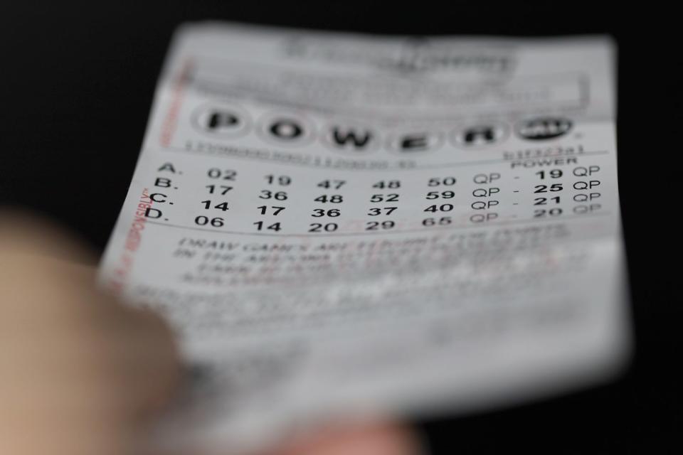 <p>Getty</p> A hand holds an expired Arizona Powerball lottery ticket with a black background on December 20, 2021 in North Las Vegas, Nevada.