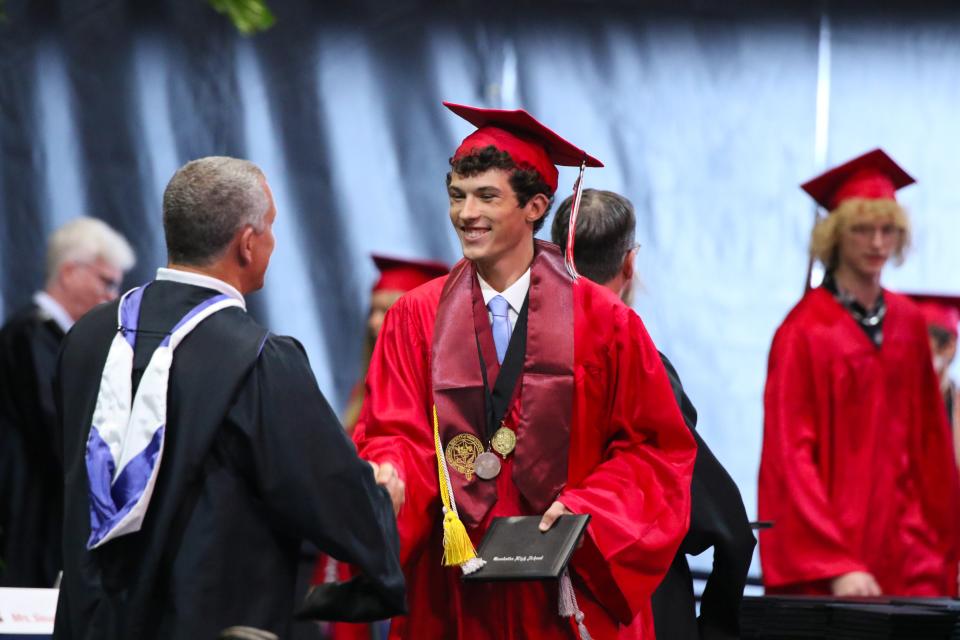 A Creekside High graduate accepts his diploma Saturday, May 28, 2022, at UNF Arena in Jacksonville.