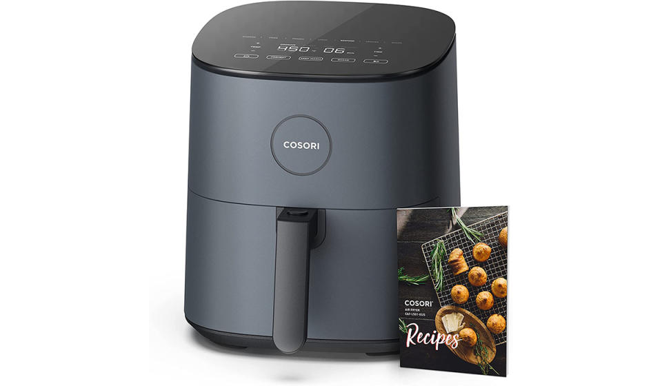 An air fryer with a recipe book next to it