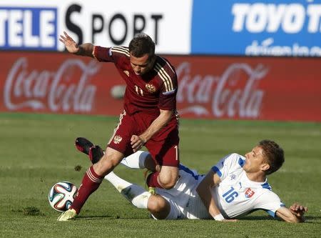 Russia's Aleksandr Kerzhakov (L) fights for the ball with Slovakia's Kornel Salata during their friendly soccer match in the Petrovsky Stadium in St. Petersburg May 26, 2014. REUTERS/Sergei Karpukhin