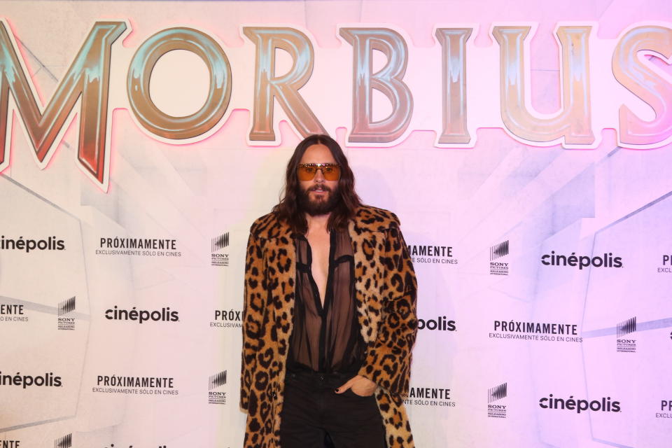 Leto poses for a photo while wearing a coat and with his hand in his pocket