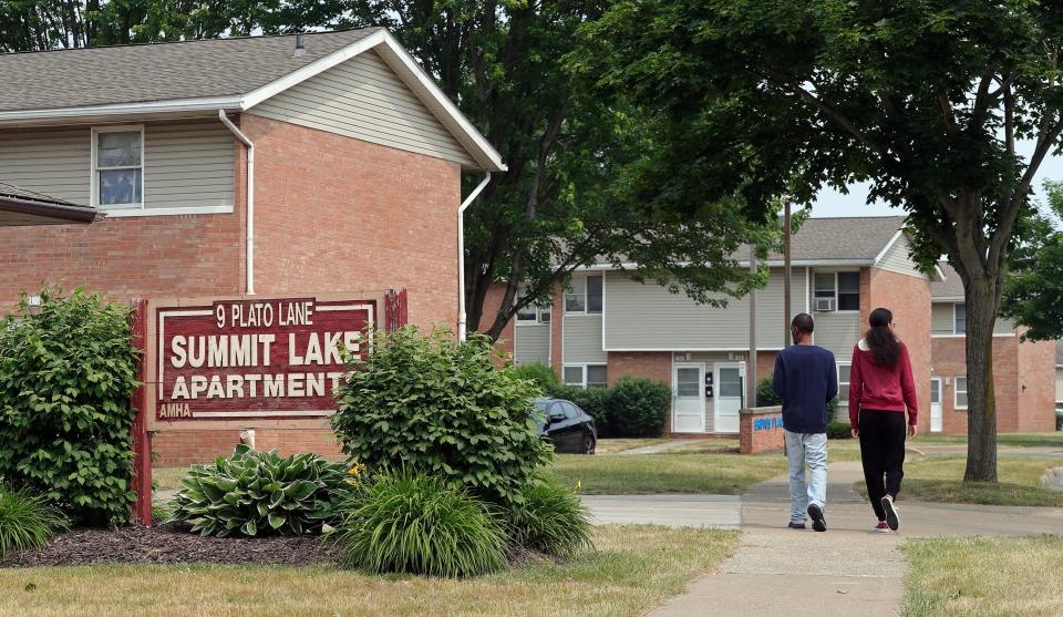 Residents walk back to their building at Summit Lake Apartments. Akron Metropolitan Housing Authority has a $170 million-plus plan to rebuild the low-income apartment complex and add other housing options to vacant lots in the neighborhood.