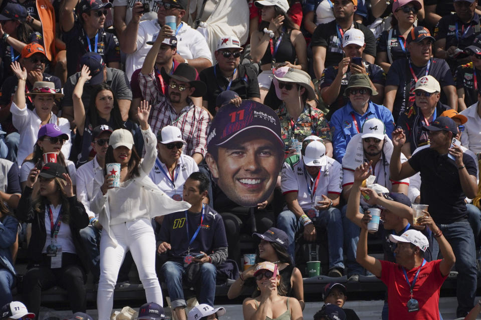 Los aficionados alientan al piloto mexicano Sergio Pérez de Red Bull contra el Ferrari de Charles Leclerc en la largada del Gran Premio de México de Fórmula Uno, el domingo 29 de octubre de 2023, en el Autódromo Hermanos Rodríguez. (AP Foto/Marco Ugarte)