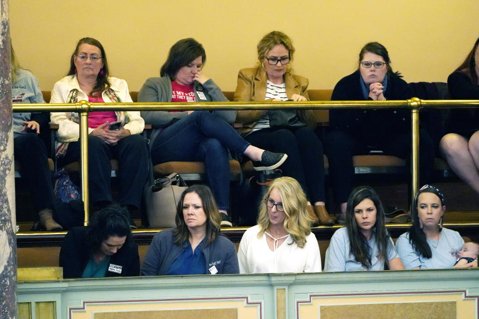 Opponents of vaccination mandates watch from the Senate gallery, Wednesday, March 9, 2022, at the Mississippi Capitol in Jackson, Miss., as senators debate a bill that says Mississippi government entities could not withhold services or refuse jobs to people who choose not to get vaccinated against COVID-19. The bill will go to final negotiations between the House and Senate. (AP Photo/Rogelio V. Solis)
