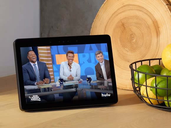 Echo Show on a counter next to a wire bowl holding lemons and limes