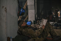 In this photo provided by Azov Special Forces Regiment of the Ukrainian National Guard Press Office, A Ukrainian soldier does crossword as he has a rest in his shelter in Mariupol, Ukraine, May 7, 2022. For nearly three months, Azovstal’s garrison clung on, refusing to be winkled out from the tunnels and bunkers under the ruins of the labyrinthine mill. A Ukrainian soldier-photographer documented the events and sent them to the world. Now he is a prisoner of the Russians. His photos are his legacy.(Dmytro Kozatsky/Azov Special Forces Regiment of the Ukrainian National Guard Press Office via AP)