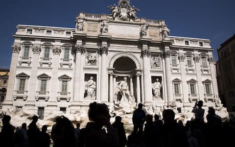 Tourists are routinely fined for leaping into the shallow waters of the Trevi Fountain in Rome - Credit: Marco Bertorello/AFP