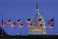 Lowered to half-staff in honor of former Senate Majority Leader Bob Dole of Kansas, flags fly in the breeeze before dawn on the National Mall with the U.S. Capitol in the background, Monday, Dec. 6, 2021, in Washington. (AP Photo/J. David Ake)