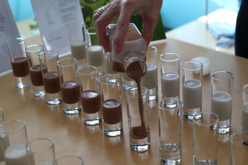 A staff member pours a malt and cocoa oat milk drink during a media presentation at Nestle in Vevey