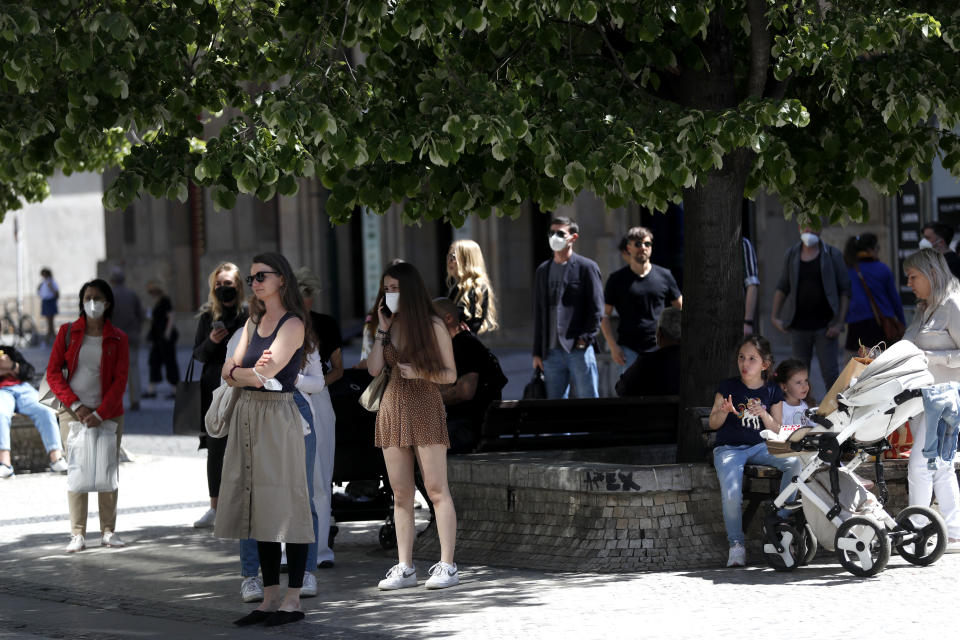 People wait in line in front of a shop in Prague, Czech Republic, Monday, May 10, 2021. The Czech Republic is massively relaxing its coronavirus restrictions as the hard-hit nation pay respect to nearly 30,000 dead. Monday's wave of easing came after the new infections fell to the levels unseen from August when the government failed to react in time to an opposite trend, the growing numbers of infected which later contributed to record numbers of deaths. (AP Photo/Petr David Josek)