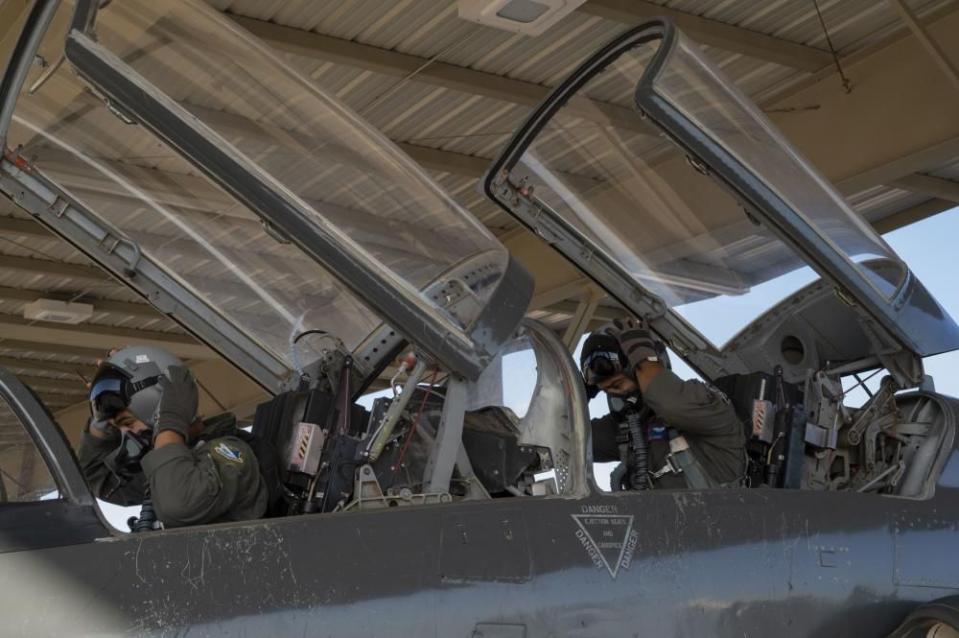 1st Lt. Julian Flores, left,, 47th Student Squadron student pilot, and 1st Lt. Gabriel Martinez, 87th Flying Training Squadron instructor pilot, adjust their helmets as they prepare for a T-38 Talon flight at Laughlin Air Force Base, Texas, July 25, 2022. (Airman 1st Class Kailee Reynolds/Air Force)