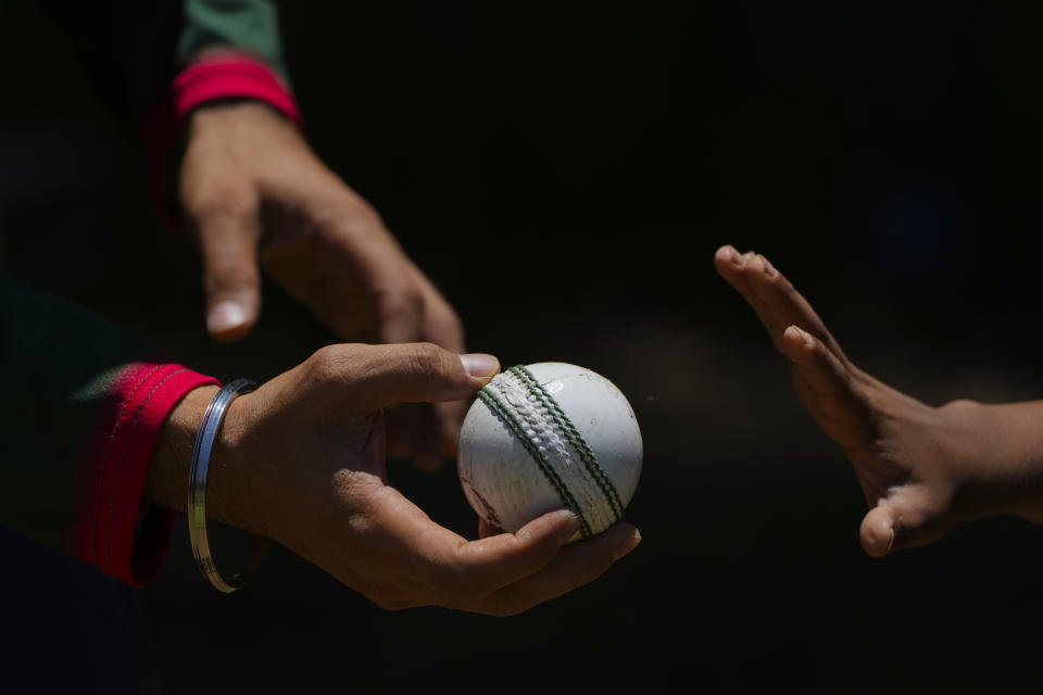 Cricket coach Gurpreet Singh, left, shows Aarush Atulannant how to grip the ball during his first training session at Reforma Athletic Club in Mexico City, Saturday, June 15, 2024. Atulannant arrived from India one month prior with his parents who moved to Mexico to work with a multinational company from India. (AP Photo/Fernando Llano)