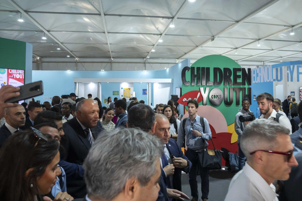 Sameh Shoukry, COP27 president, center left, walks in the youth pavilion at the COP27 U.N. Climate Summit, Wednesday, Nov. 9, 2022, in Sharm el-Sheikh, Egypt. (AP Photo/Nariman El-Mofty)