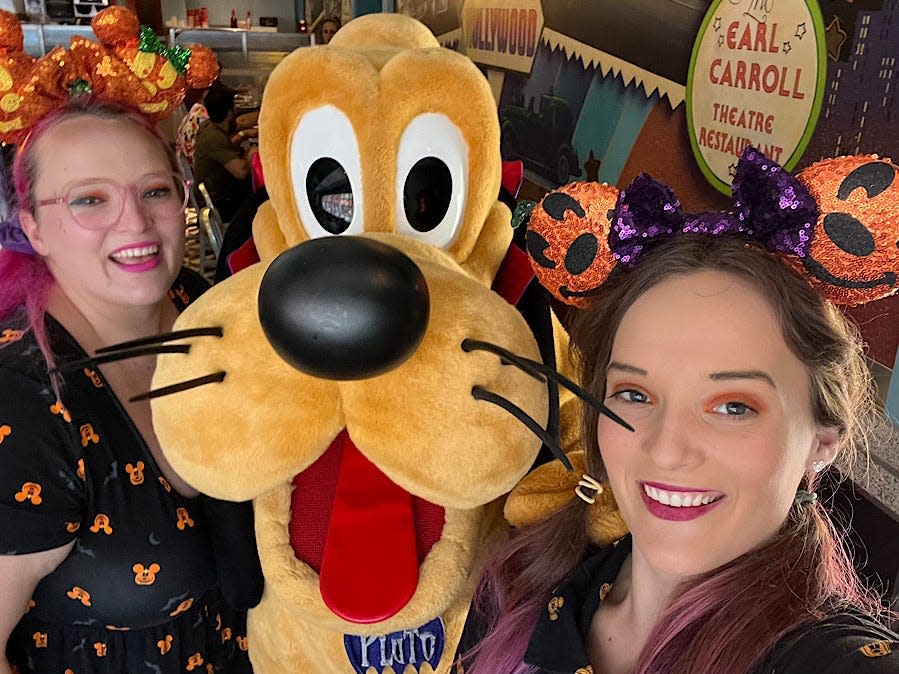 casey and jenna posing with pluto at hollywood and vine in disney world