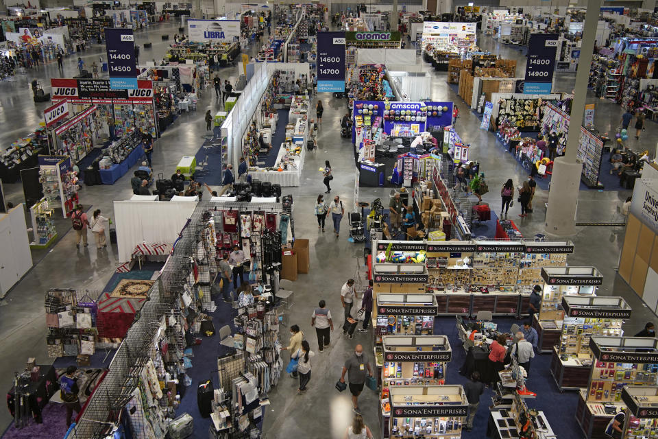 People walk through the convention floor at the ASD Market Week convention Wednesday, Aug. 25, 2021, in Las Vegas. In pre-COVID times, business events like conferences and trade shows routinely attracted more than 1 billion participants and $1 trillion in direct spending each year. The pandemic brought those gatherings to a sudden halt, and now in-person meetings are on the rebound from Las Vegas to Beijing. (AP Photo/John Locher)